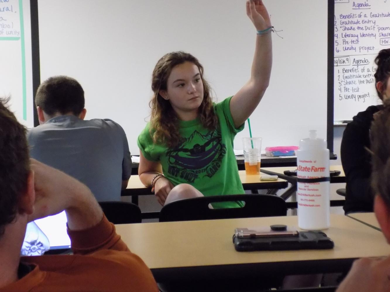 Sophomore Anna Hergert raises her hand to respond during a current event discussion. 
