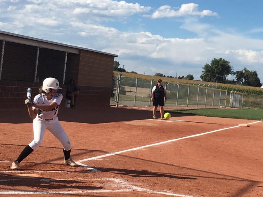Freshman Maddox Boston (#7) prepares to swing as the ball is pitched at the softball game against Windsor on September 11.