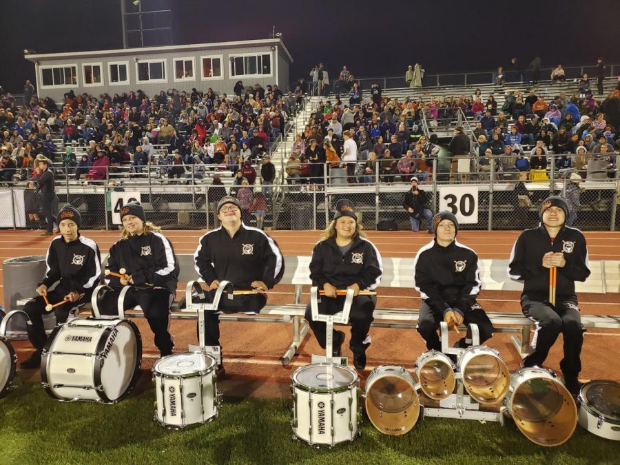 The MHS Unified Percussion class waits on the benches at a 2019 Mead football game.