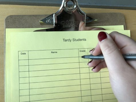 A student getting ready to sign the Tardy Sheet, trying to come up with an excuse for being late.