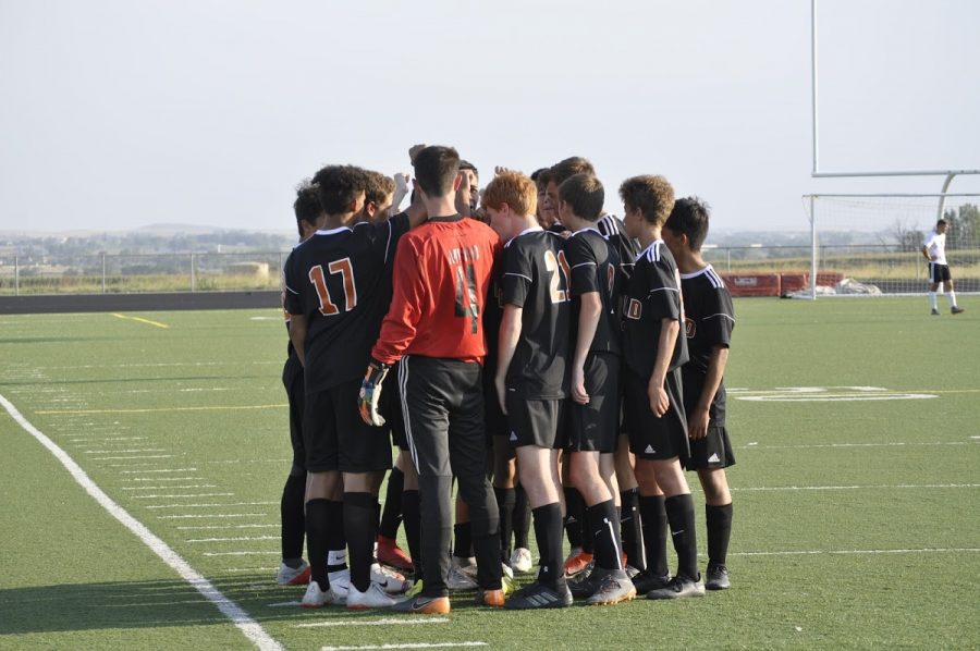 The 2019-2020 season Boys Soccer team huddles on the field. 