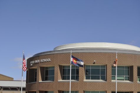 A wind storm sweeps across Colorado and moves the flags at the front of the school.