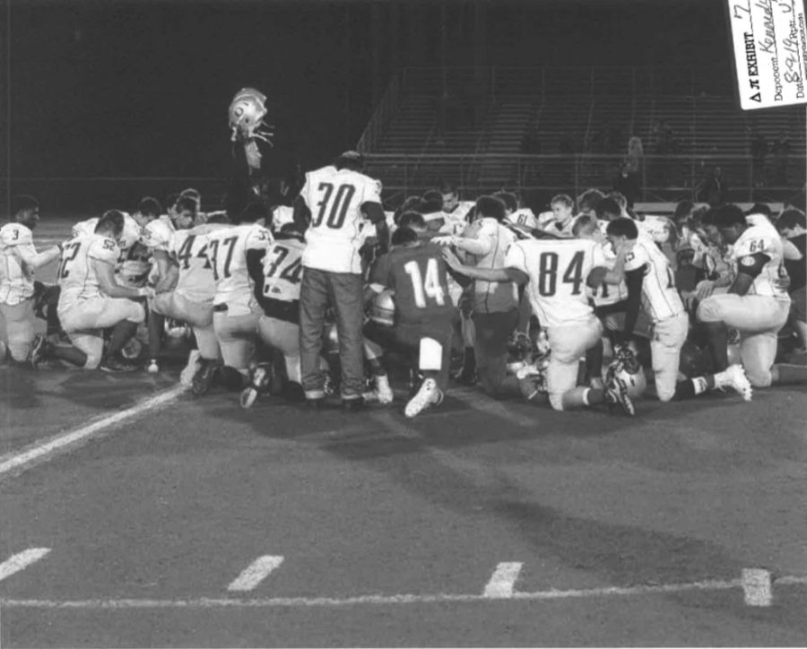 Kennedy kneels with his players following a game. (Photo used in dissenting opinion by Justice Sotomayor.)