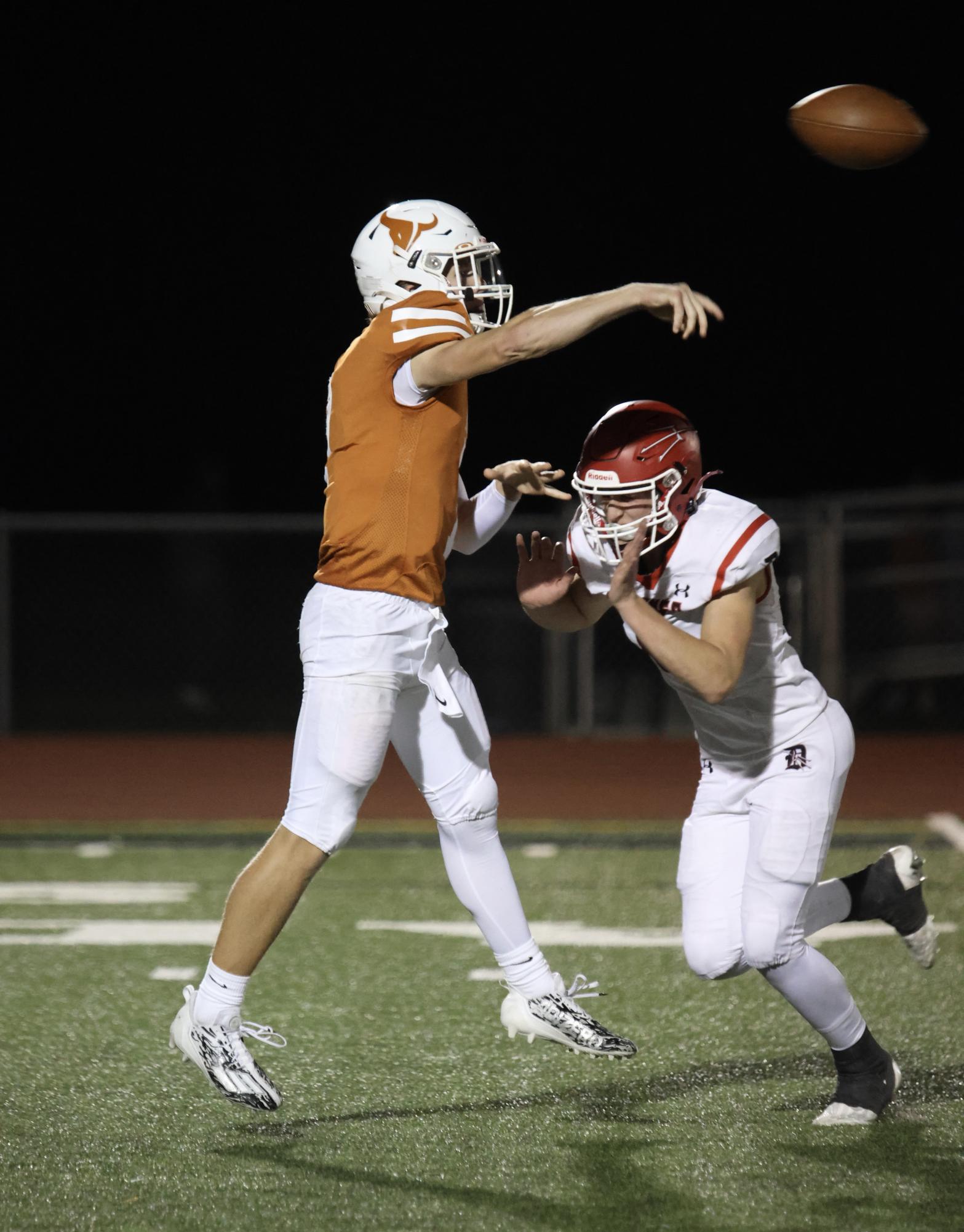Christian Hiner (‘25) throws a pass while evading a tackle in Mead’s home game against the Demons. 