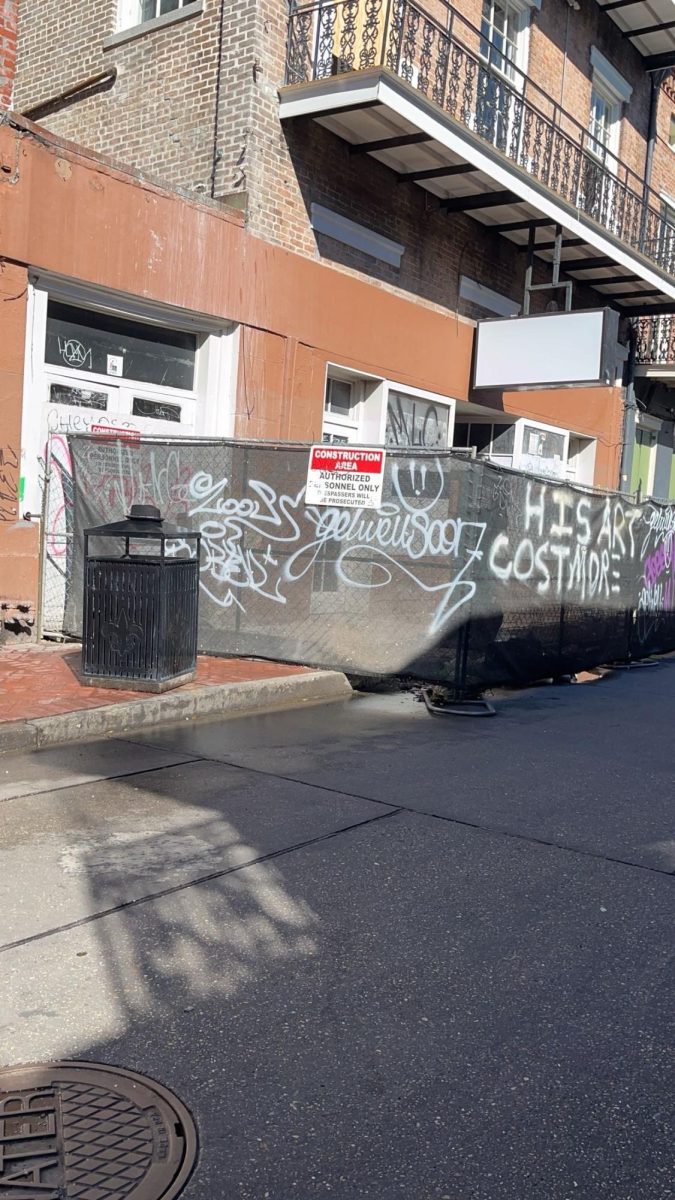 a bunch of tags on fabric covering a fence. Graffiti is expression in so many different ways.